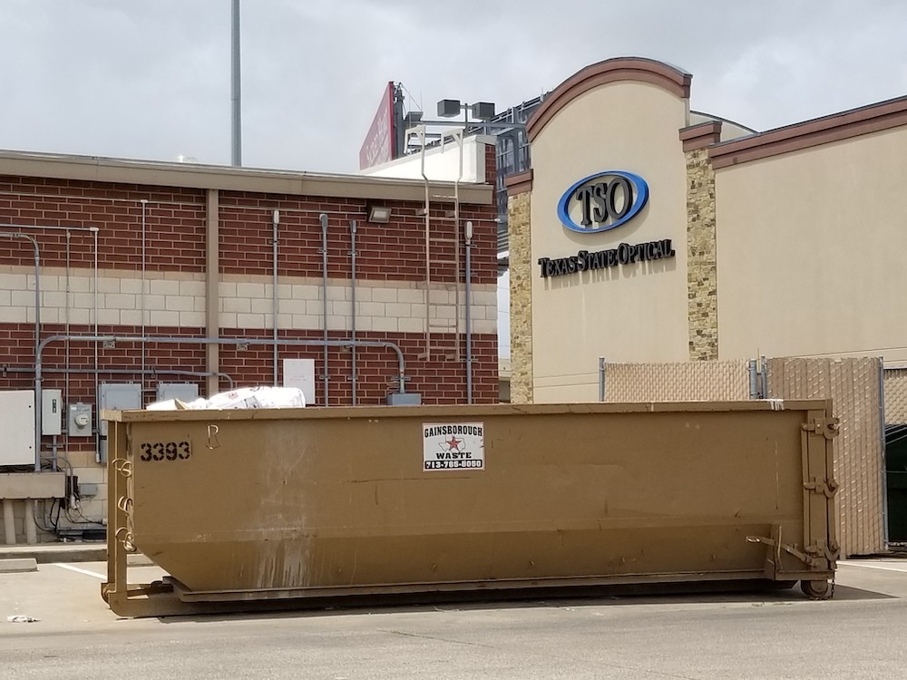 A commercial dumpster rental in use at a business location in Houston
