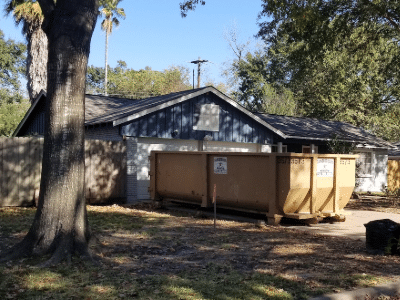 A clean Gainsborough Waste roll-off dumpster positioned in the driveway of a Cypress-area home undergoing renovation.